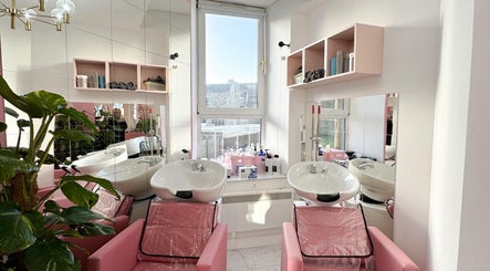 Modern hair washing area at Aberdeen Millmo salon in Aberdeen, Scotland, GB with pink chairs and plants.