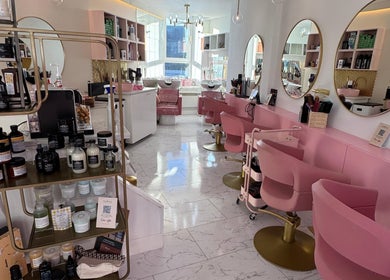 Modern interior of Aberdeen Millmo salon in Aberdeen, Scotland, GB, featuring pink chairs and stylish decor.