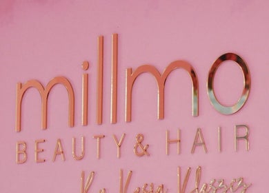 Elegant metallic logo of Aberdeen Millmo salon on pink wall, Aberdeen, Scotland, GB.