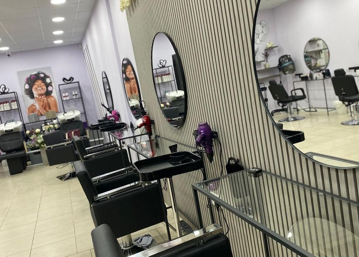 Elegant interior of Muna Salon 2 in Borehamwood, England featuring sleek styling stations and modern decor.