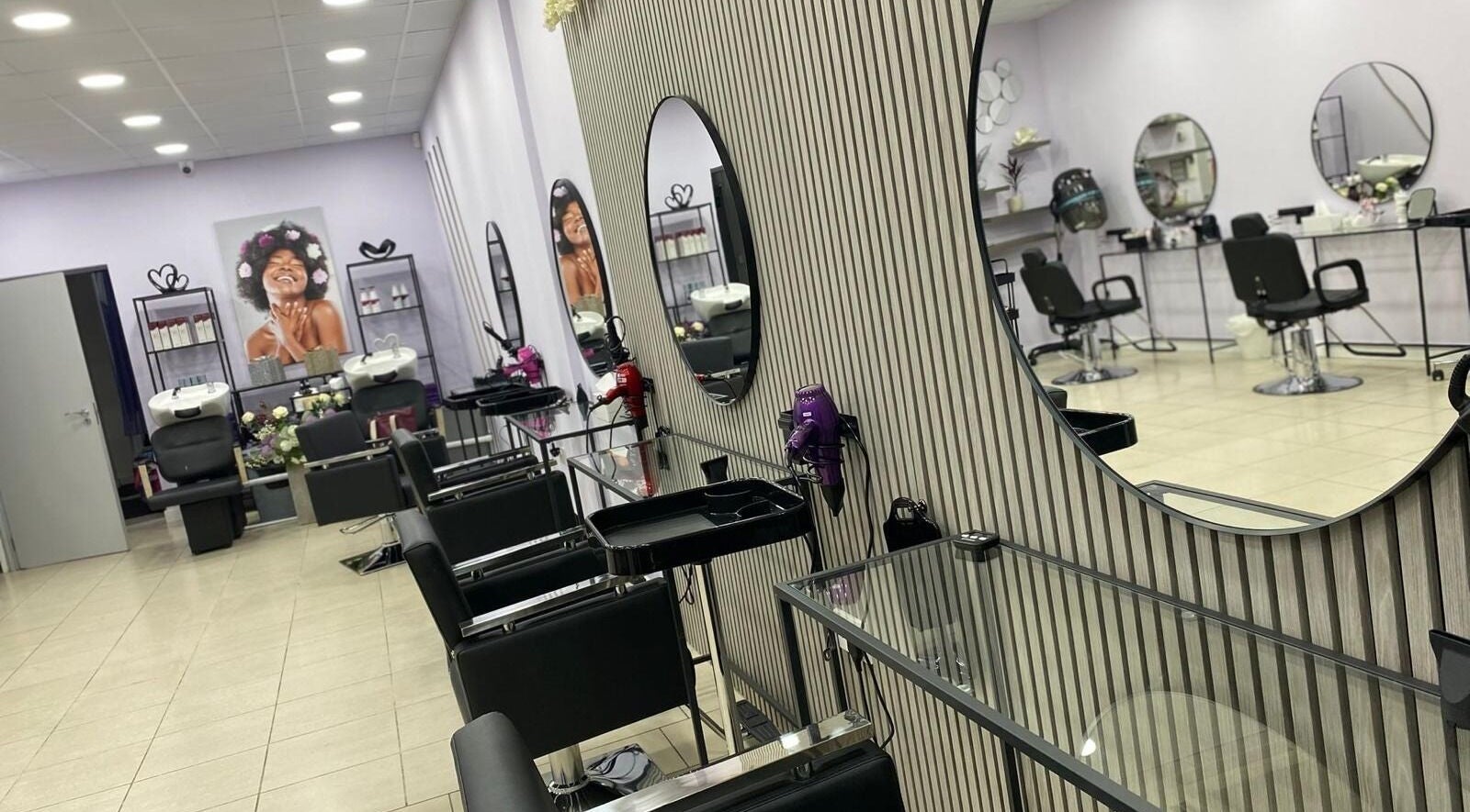 Elegant interior of Muna Salon 2 in Borehamwood, England featuring sleek styling stations and modern decor.