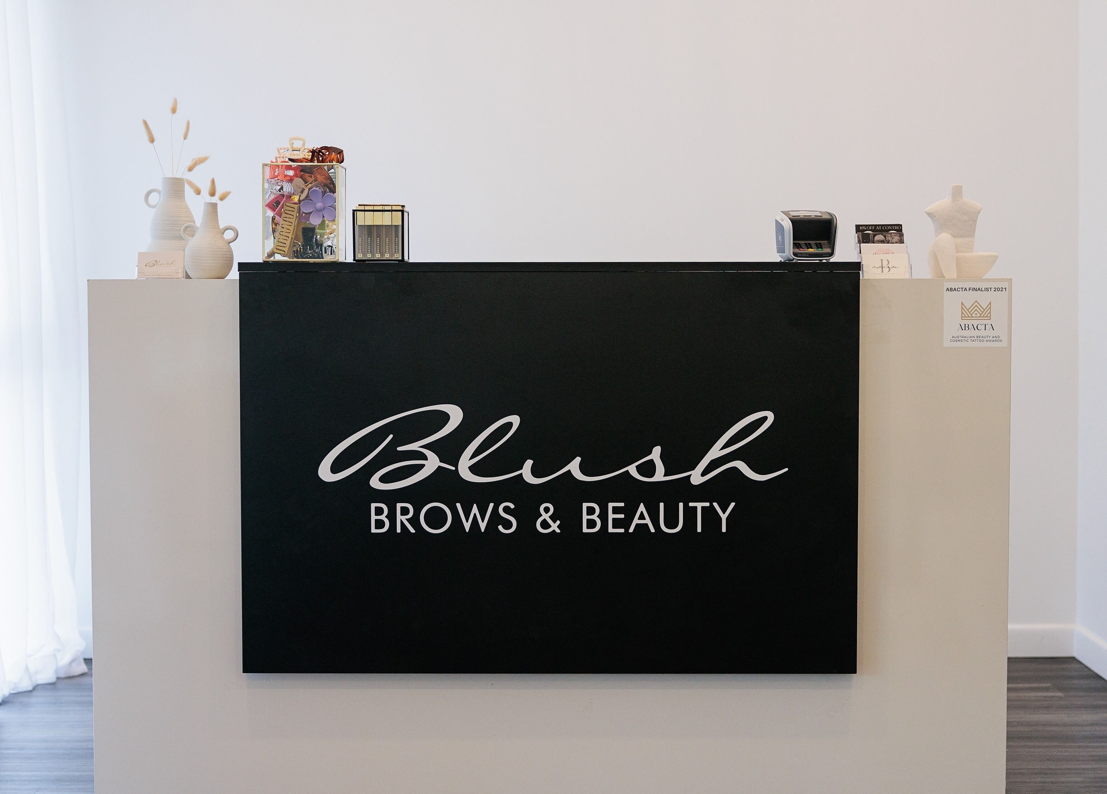 Reception desk at Blush Brows and Beauty, North Mackay, Queensland, AU, showcasing a modern and clean design.