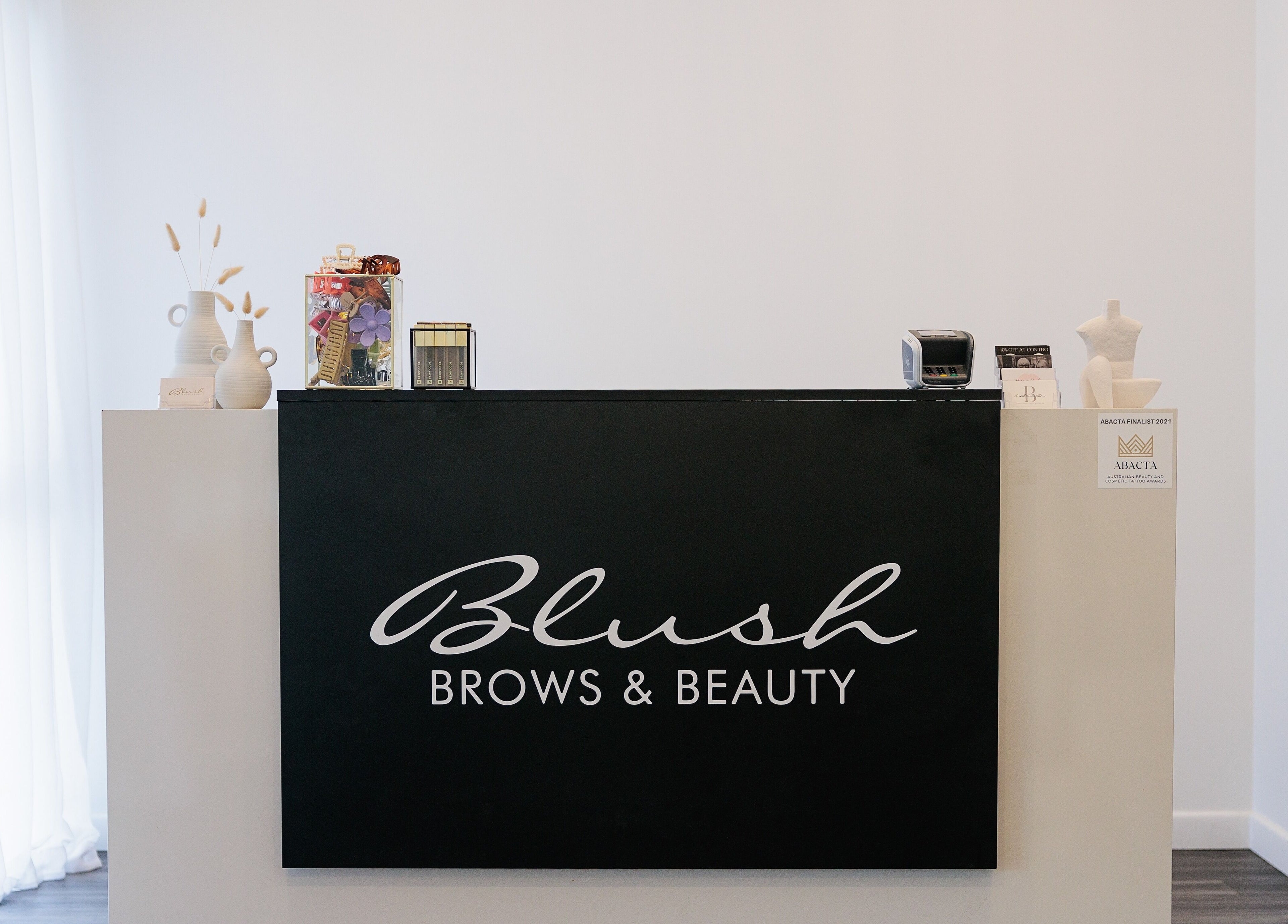 Reception desk at Blush Brows + Beauty & Tattoo Removal Mackay in North Mackay, Queensland, AU.