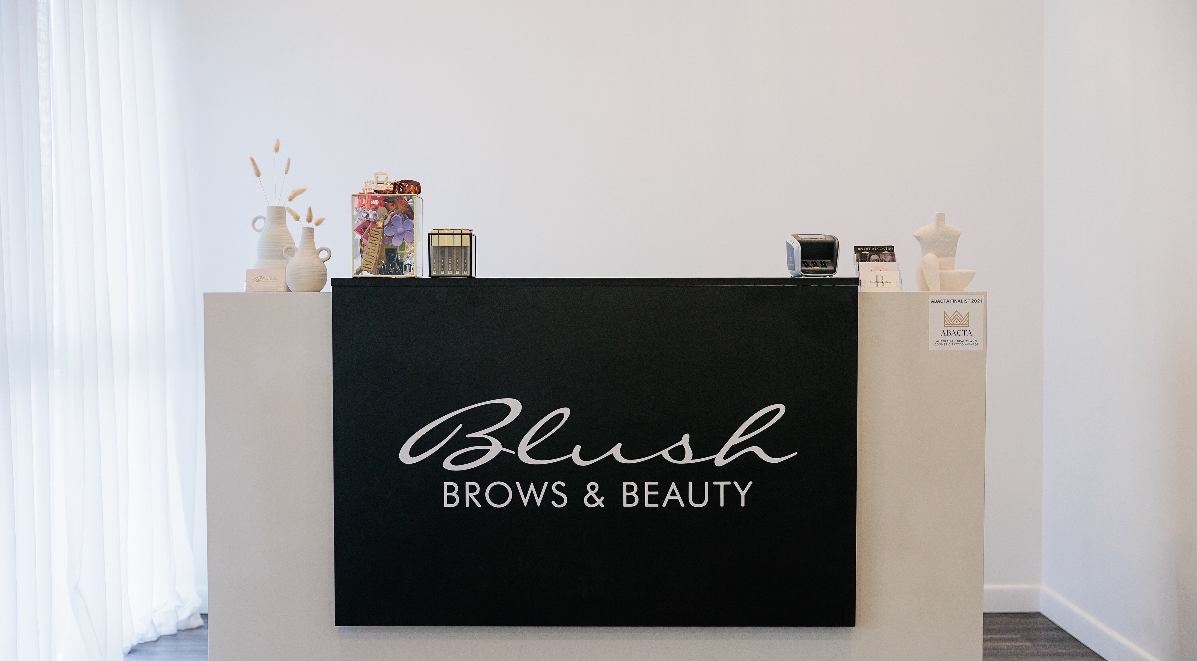 Reception desk at Blush Brows + Beauty & Tattoo Removal Mackay in North Mackay, Queensland, AU.