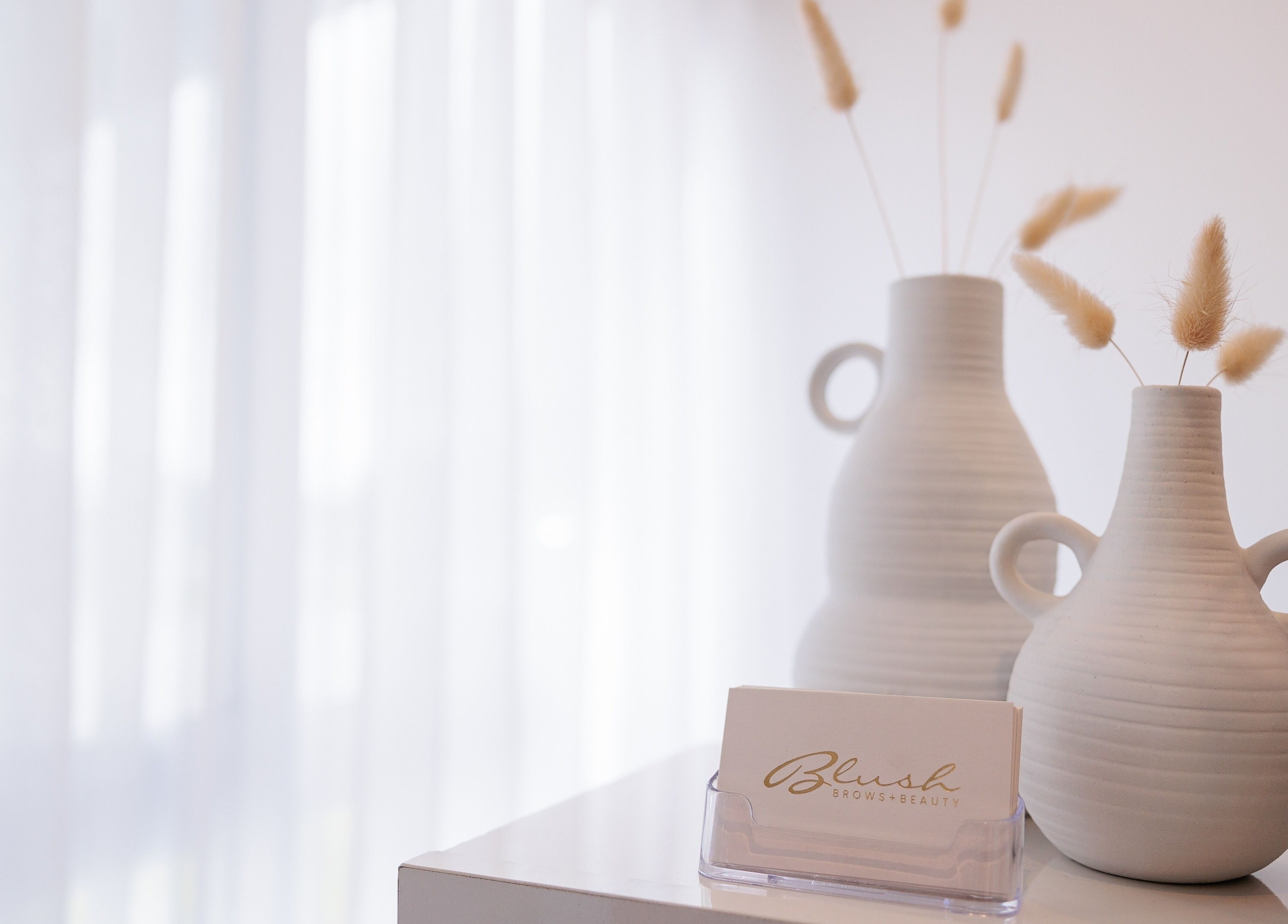 Elegant vases and business card at Blush Brows + Beauty & Tattoo Removal Mackay, North Mackay, Queensland, AU.
