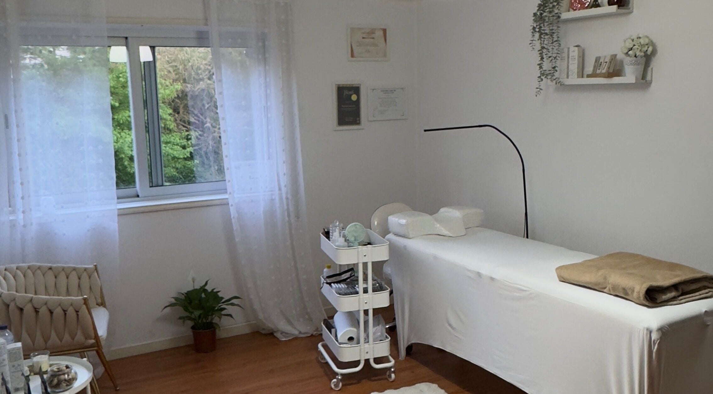 Sala de tratamento relaxante em Karen Gouveia Beauty & Co., Braga, Braga, PT, com mesa de massagem e decoração suave.