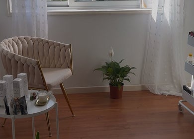 Espaço relaxante em Karen Gouveia Beauty & Co., Braga, Braga, PT com cadeira elegante e mesa de produtos.