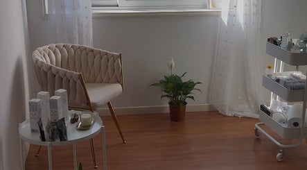 Espaço relaxante em Karen Gouveia Beauty & Co., Braga, Braga, PT com cadeira elegante e mesa de produtos.