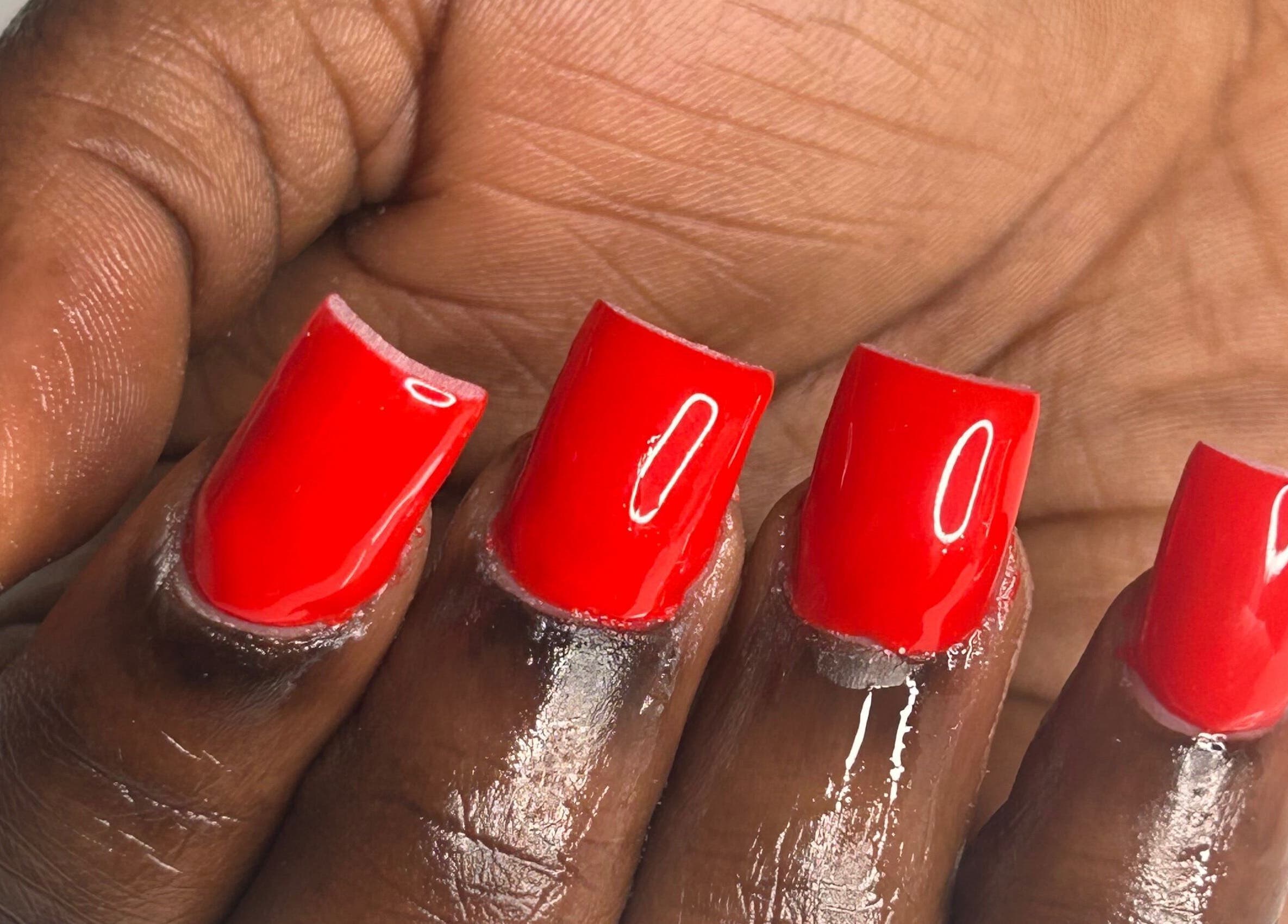 Bold red manicure at Nailsbylamie in Luton, England, GB, showcasing glossy square-shaped nails.