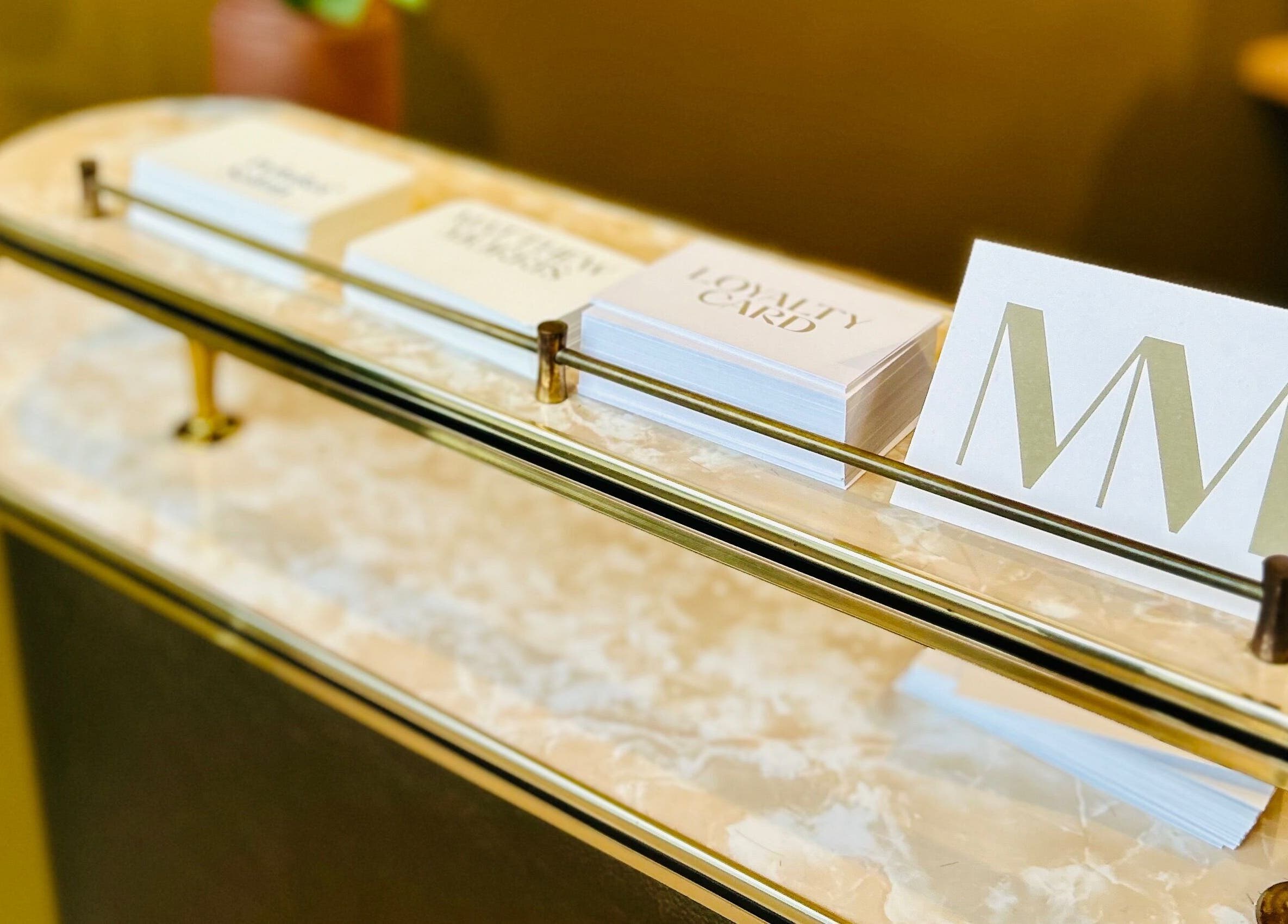 Reception desk at Matthew Morris with Peluka Salon, Southend on Sea, England, GB, displaying loyalty cards.