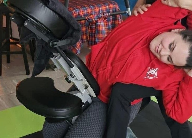 Chair massage at Massage & Beauty By Miky, In-naxxar, MT. Client stretches for ultimate relaxation.