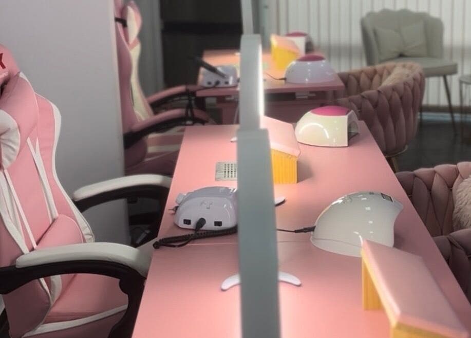 Интериор на салон The Pink Castle в София, с розови столове и маси за маникюр.
