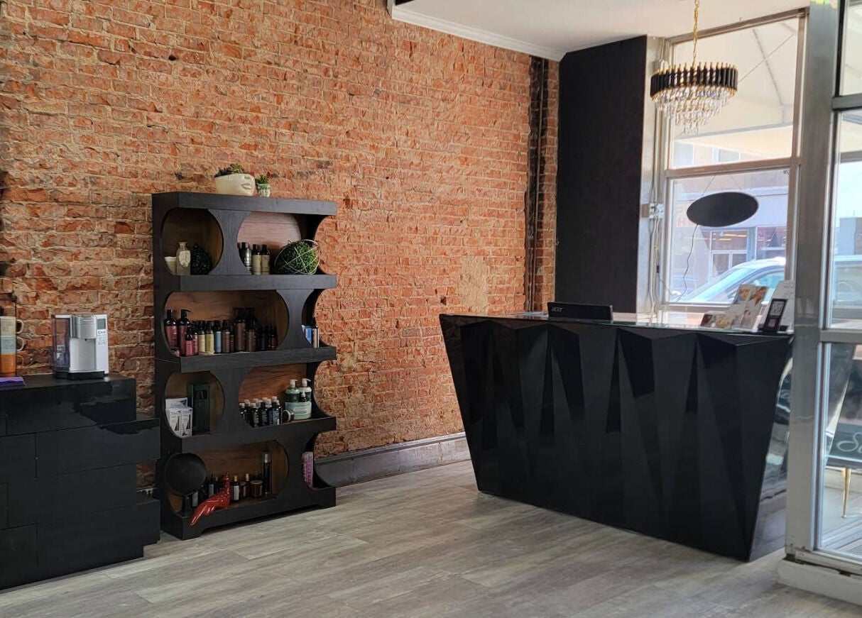 Reception area at Emmah at Transcendence Salon & Spa showcasing a chic brick wall in Columbus, Nebraska, US.