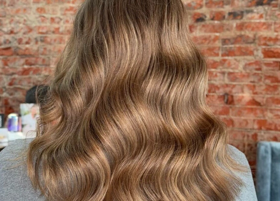 Glossy, wavy hair showing a rich color transformation at Emmah, Transcendence Salon & Spa, Columbus, Nebraska, US.