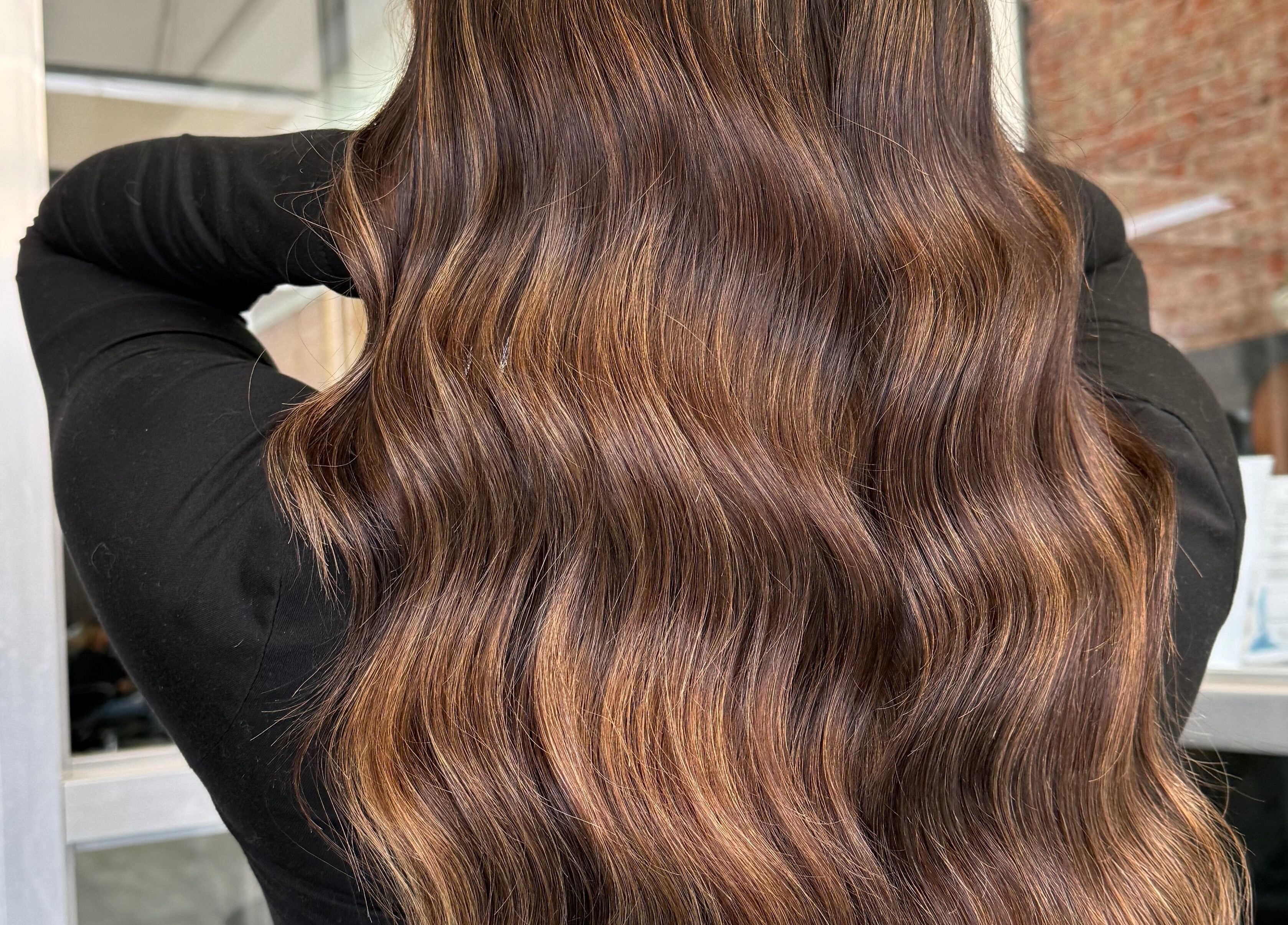 Rich, wavy brunette hair at Emmah at Transcendence Salon & Spa, Columbus, Nebraska, US.