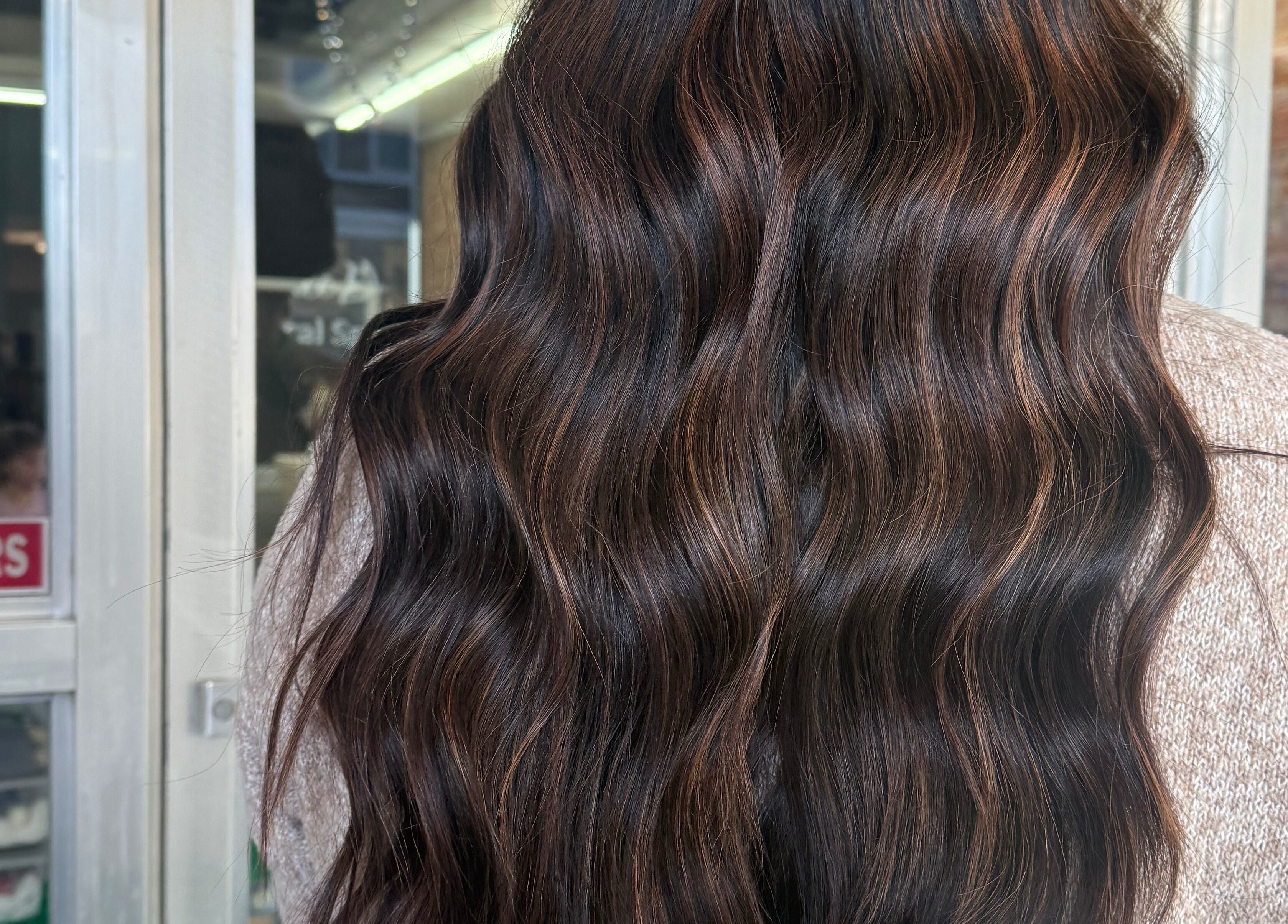 Elegant wavy brunette hair styled at Emmah at Transcendence Salon & Spa, Columbus, Nebraska, US.