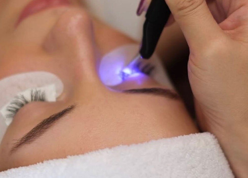 Eye treatment at Alpha Lash & Brow, St Leonards, New South Wales, AU with glowing tool for lash enhancement.