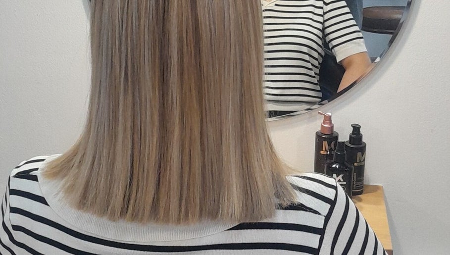 Straight hair styled at HAIR BY LILI, Pretoria, Gauteng, ZA, reflected in mirror with styling products visible.