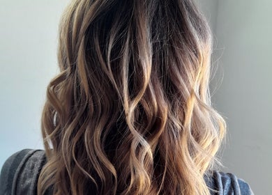 Elegant wavy hairstyle at HAIR BY LILI, Pretoria, Gauteng, ZA showcasing natural highlights.