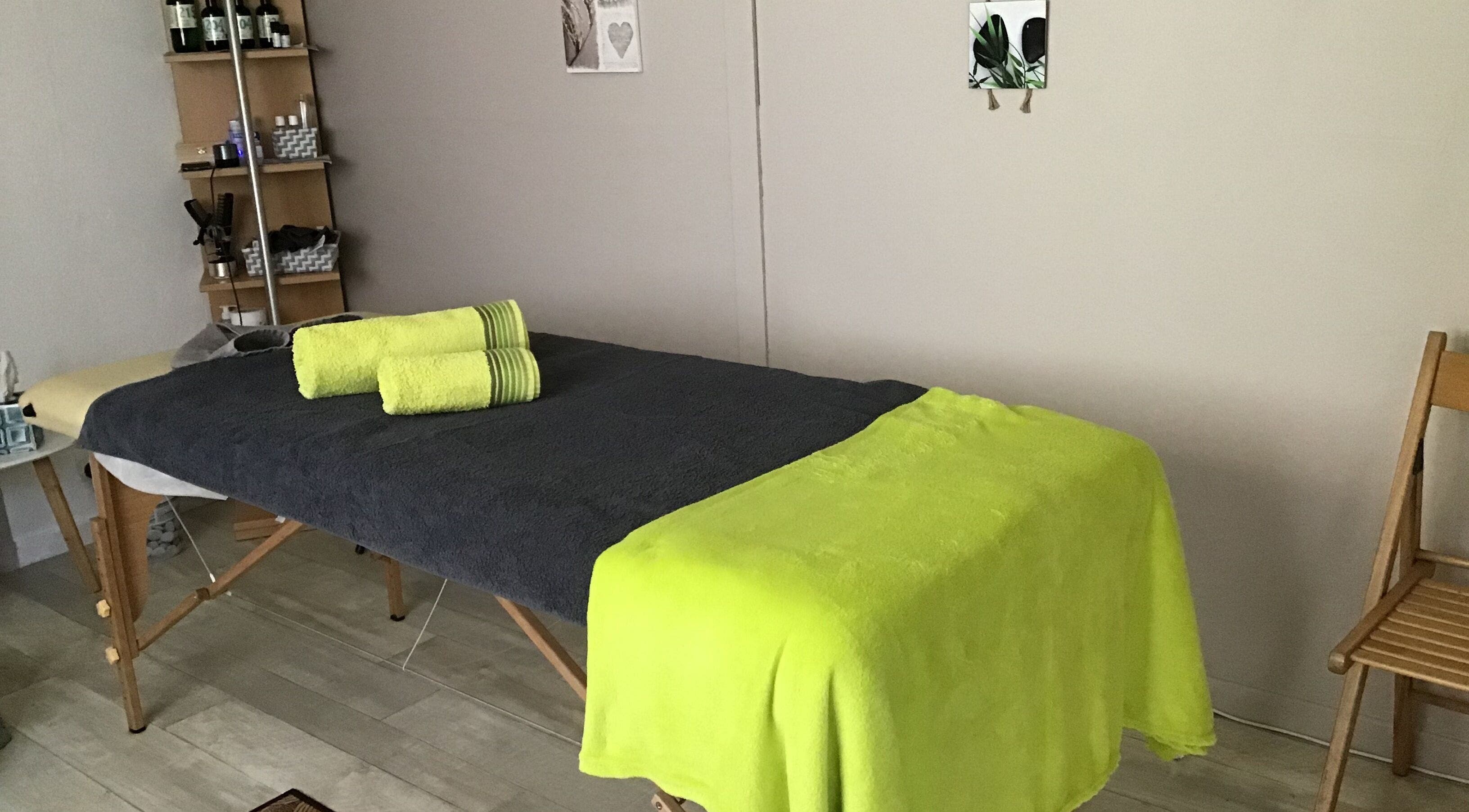 Table de massage avec serviettes vertes à Massage Bien être Patricia, La Ville-du-bois, Île-de-france, FR.