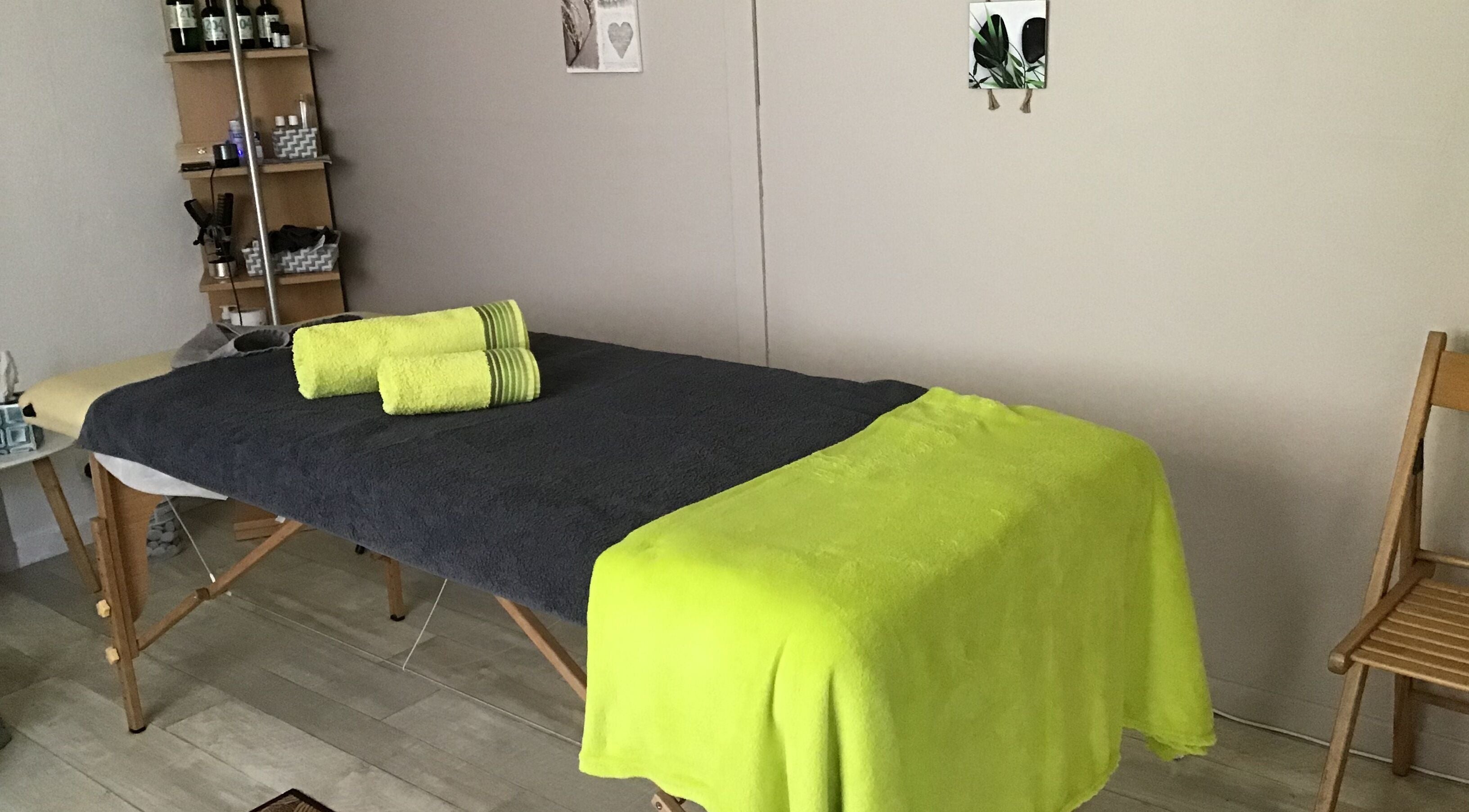 Table de massage avec serviettes vertes à Massage Bien être Patricia, La Ville-du-bois, Île-de-france, FR.