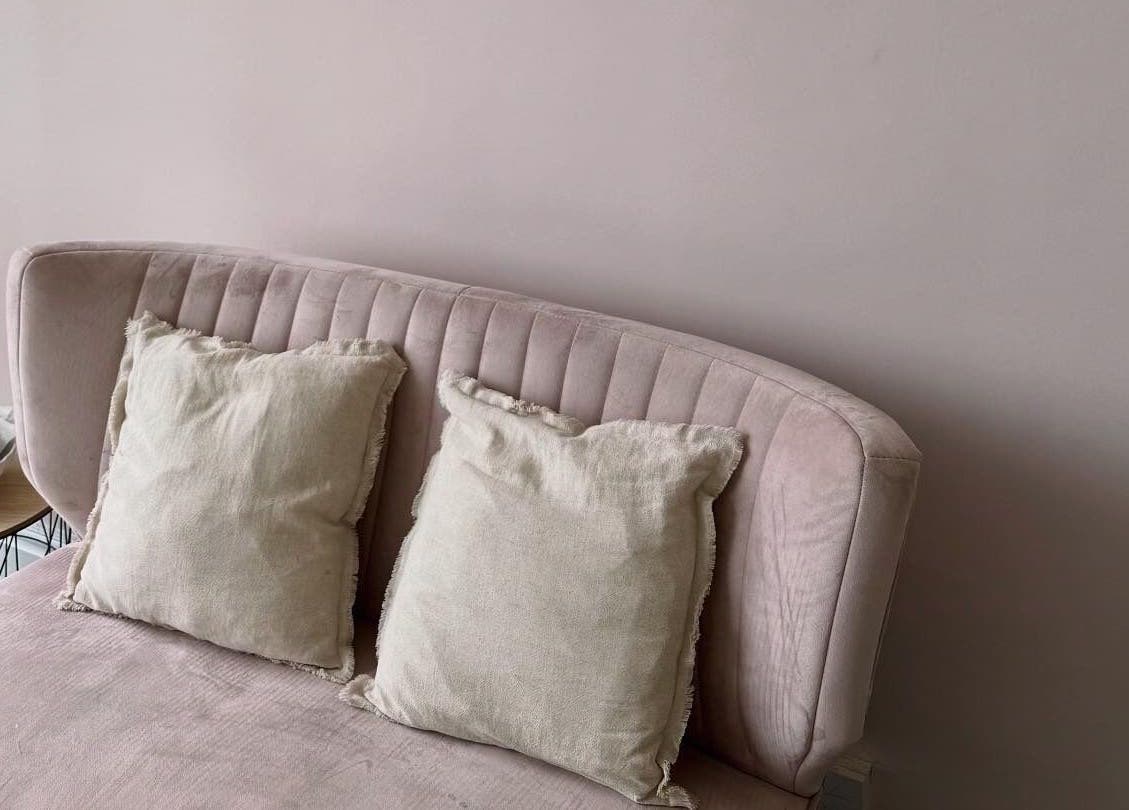 Cozy pink velvet sofa with cushions at Caits Cosmetics, Whittlesey, England, GB. Ideal for relaxation.