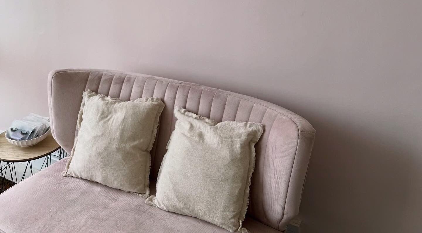 Cozy pink velvet sofa with cushions at Caits Cosmetics, Whittlesey, England, GB. Ideal for relaxation.