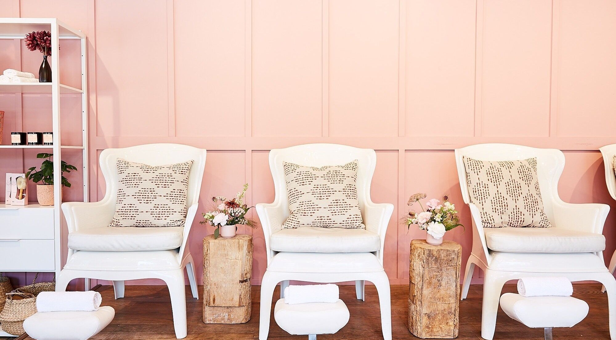 Sekai Nail and Beauty Bar in Toronto, Ontario, CA, features elegant white seating with pink decor for a relaxing vibe.