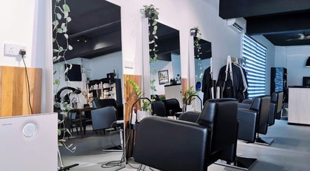 Modern salon space at Van Coiffeur Hair Studio, Malacca, MY with sleek black chairs and plant decor.