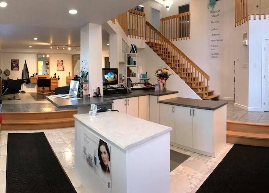 Intérieur raffiné du salon L’espace Beauté Elle Et Lui à Gatineau, Québec, CA montrant la réception et des sièges colorés.