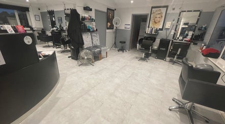 Modern interior of Cut Loose Hair Designs in Norwich, England, GB, featuring stylish chairs and mirrors.