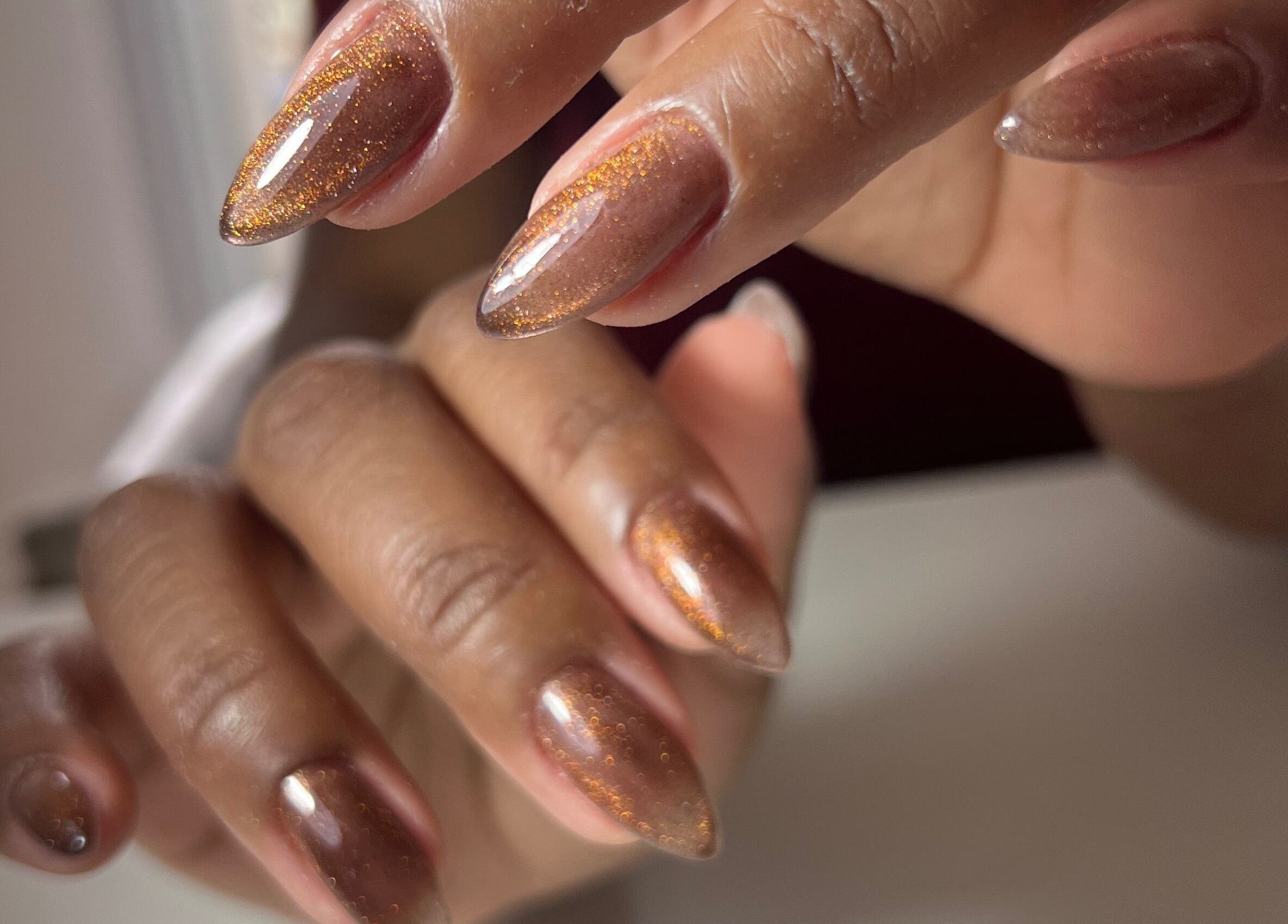 Unhas com esmalte marrom brilhante em Cris Ramos Nails, São Paulo, São Paulo, BR.