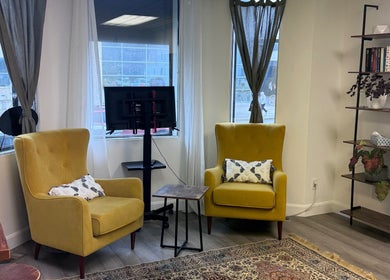 Comfortable seating area in Bien-être Boho NDG, Montréal, Québec, CA with yellow armchairs and a bookshelf.