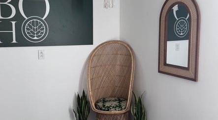 Wicker chair and mirror at Bien-être Boho NDG, Montréal, Québec, CA, create inviting ambiance.