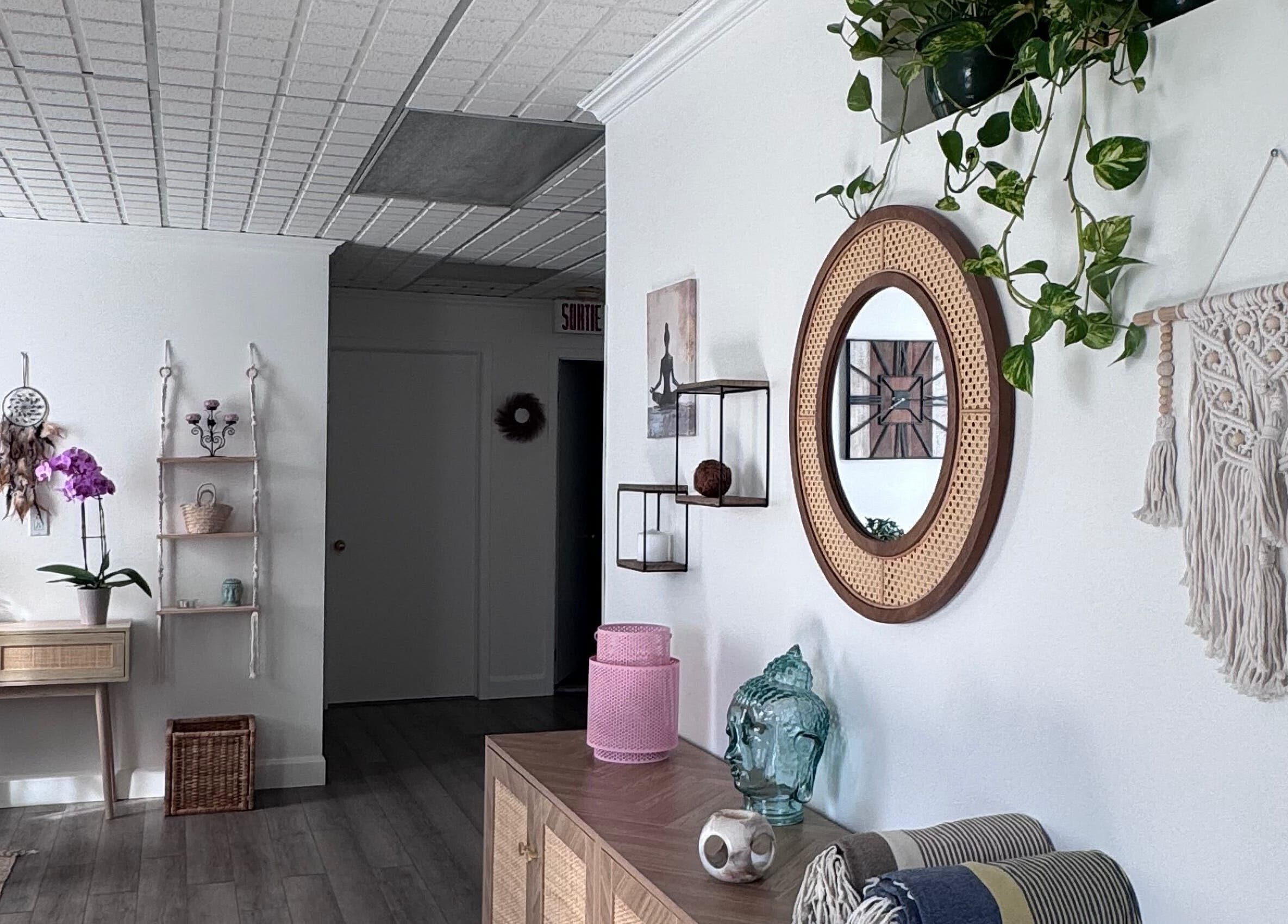 Modern boho decor at Bien-être Boho NDG, Montréal, Québec, CA, featuring plants, artwork, and a mirror.