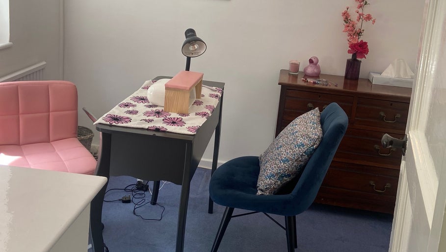 Cozy nail station at Nails by Emily, Camberley, England, GB with pink and blue chairs and floral decor.