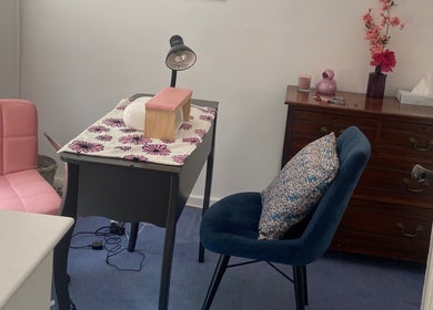 Cozy nail station at Nails by Emily, Camberley, England, GB with pink and blue chairs and floral decor.