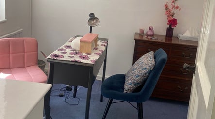 Cozy nail station at Nails by Emily, Camberley, England, GB with pink and blue chairs and floral decor.