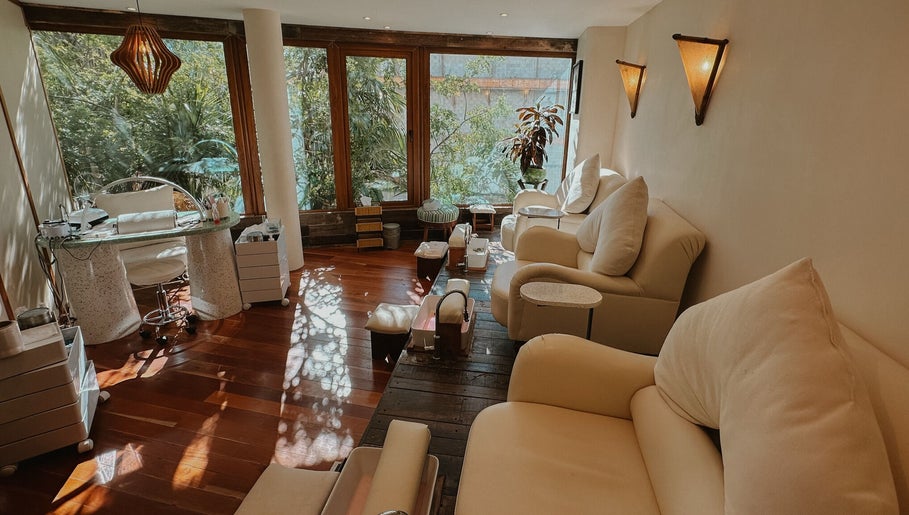 Relajante sala de masajes en Playa Harmony Spa, Playa Del Carmen, Quintana Roo, MX, con asientos cómodos y vegetación.