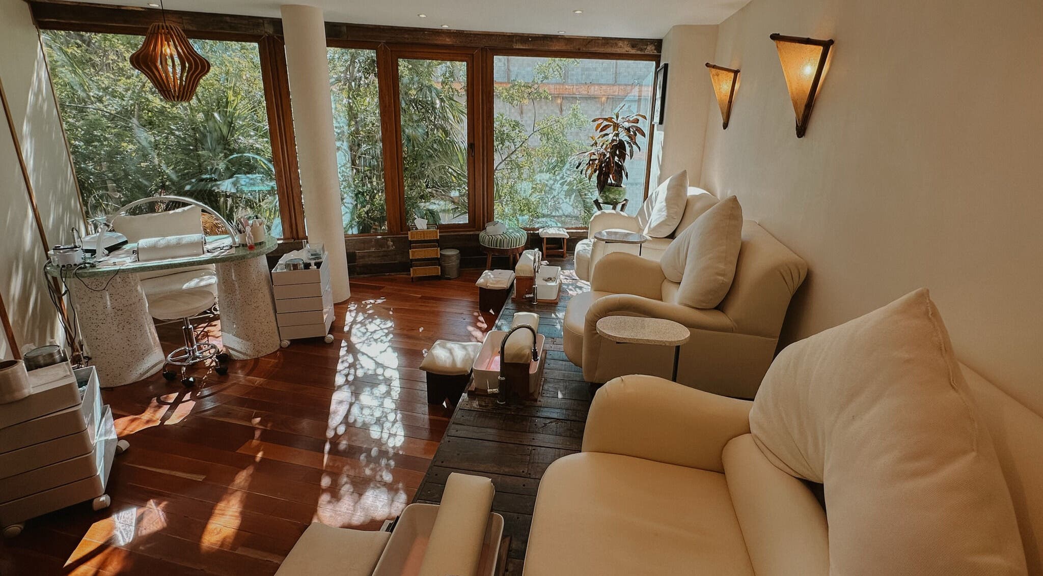 Relajante sala de masajes en Playa Harmony Spa, Playa Del Carmen, Quintana Roo, MX, con asientos cómodos y vegetación.