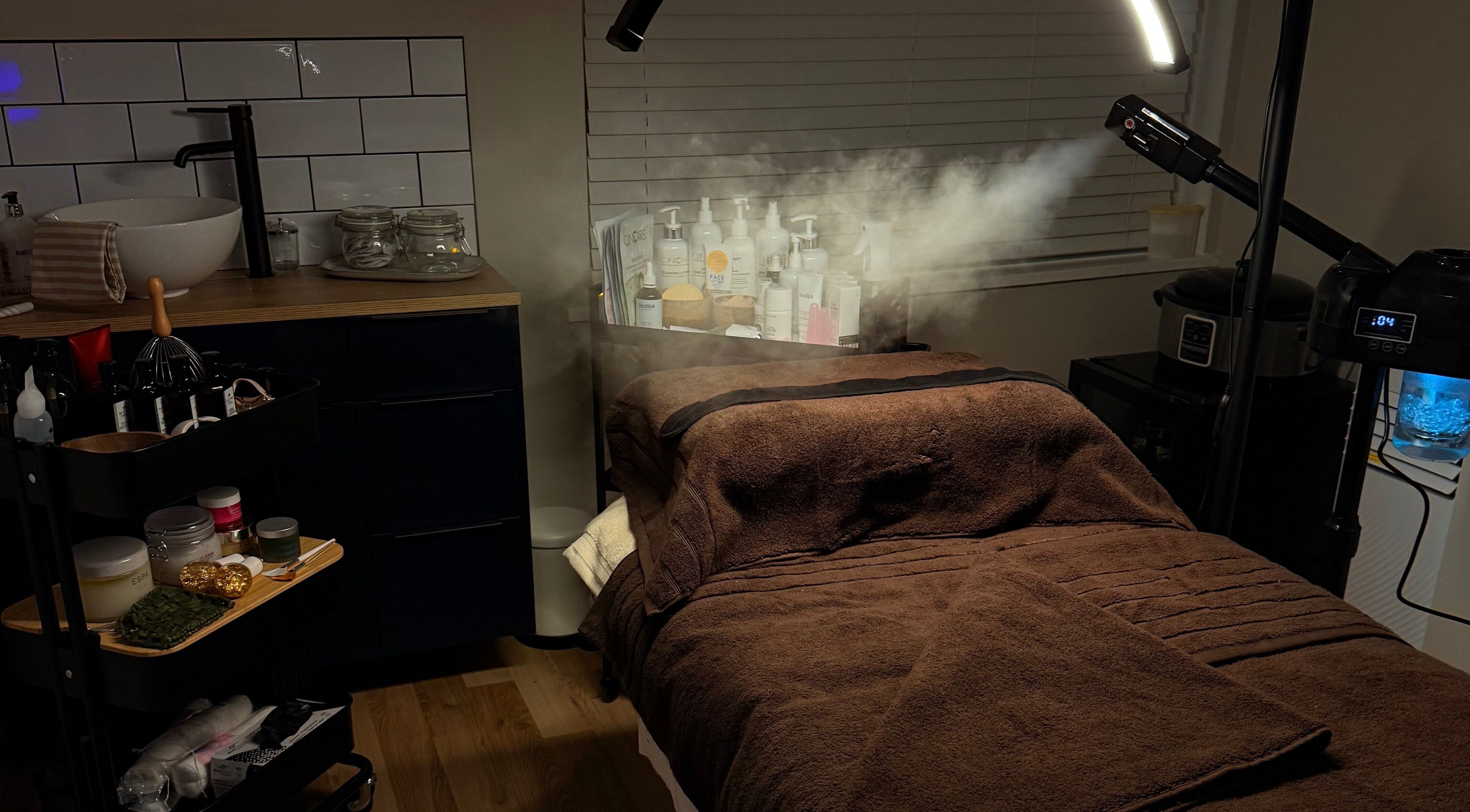 Cozy treatment room at The Skin Therapist, Bolton, England, GB, with spa essentials and ambient lighting.
