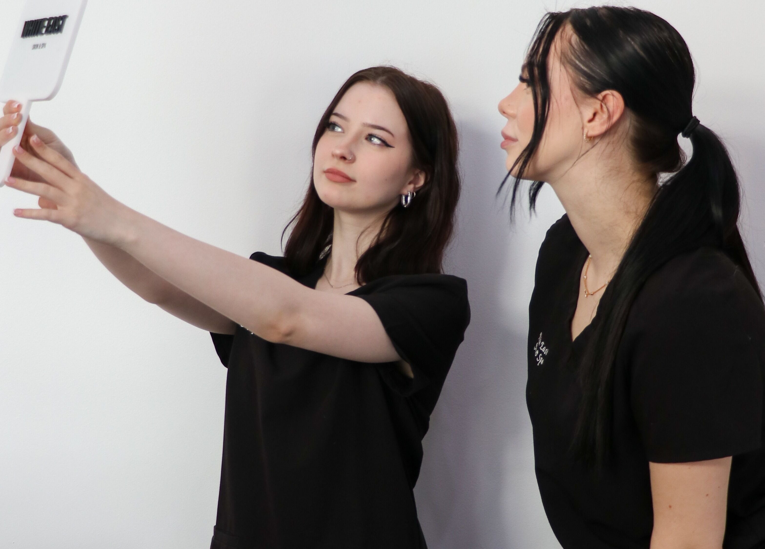 Beauticians at White East Skin & Spa, Melbourne, Victoria, AU, using a mirror for skin consultation.