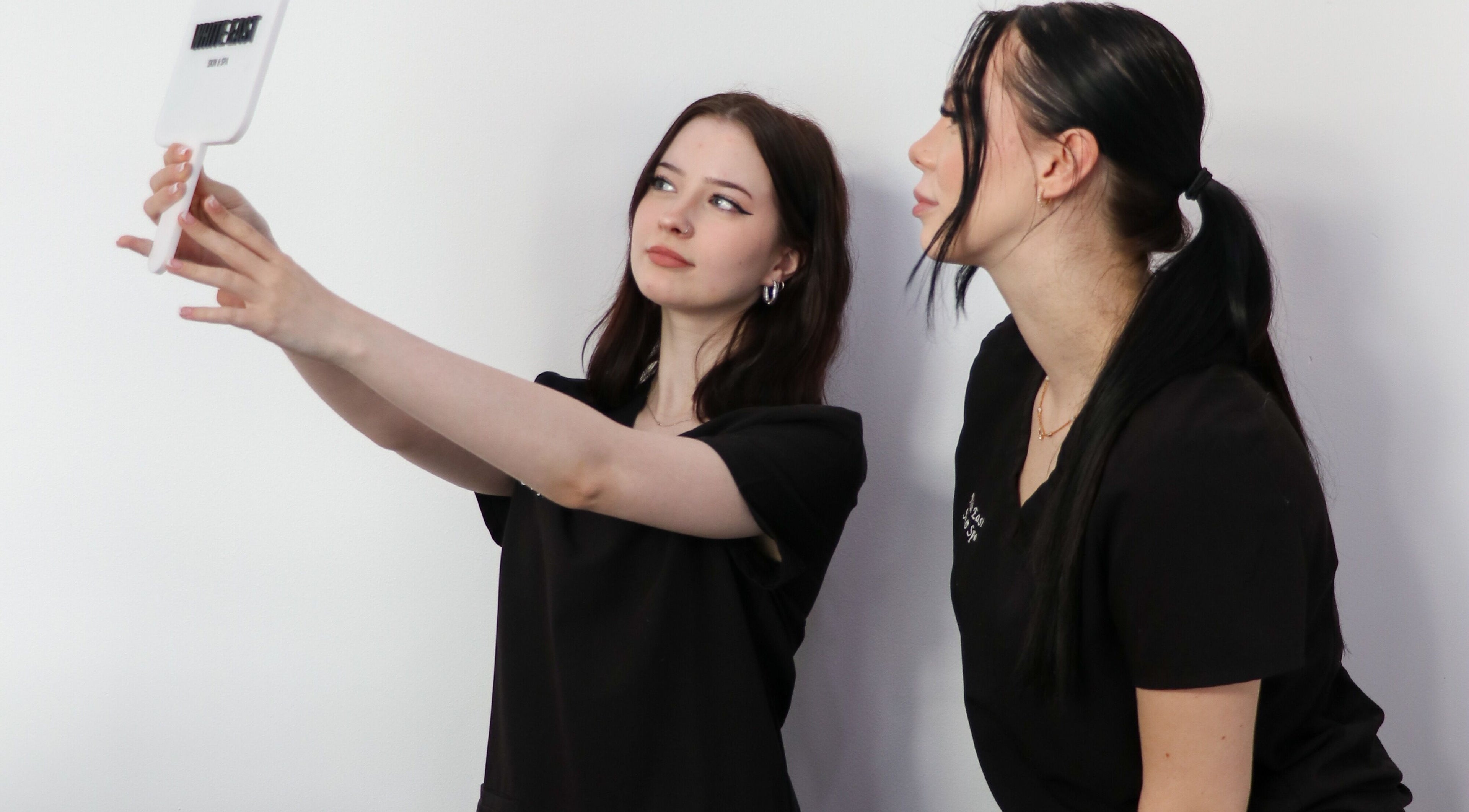 Beauticians at White East Skin & Spa, Melbourne, Victoria, AU, using a mirror for skin consultation.
