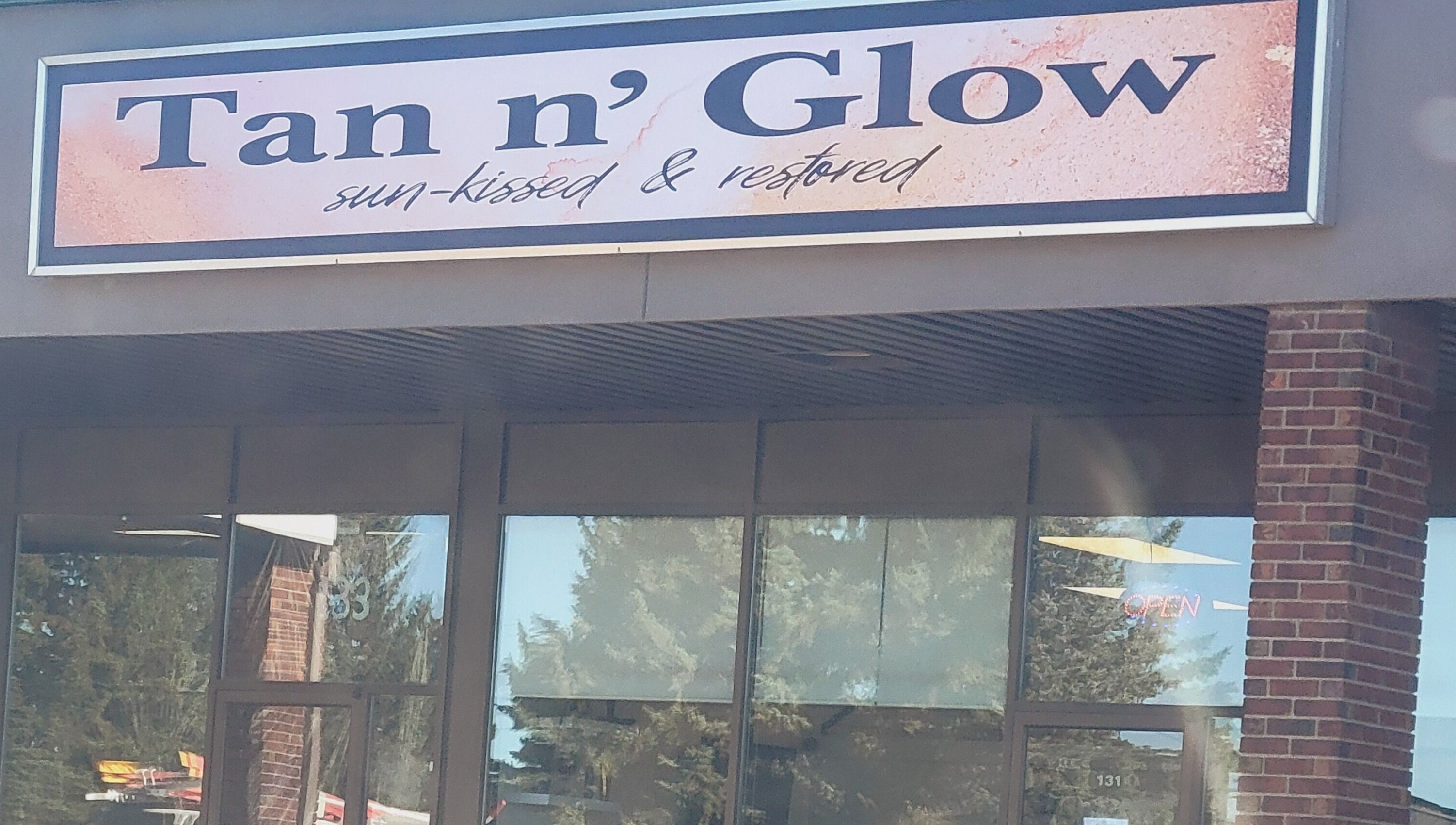 Entrance of Tan n'Glow in Medicine Hat, Alberta, CA showcasing stylish signage.