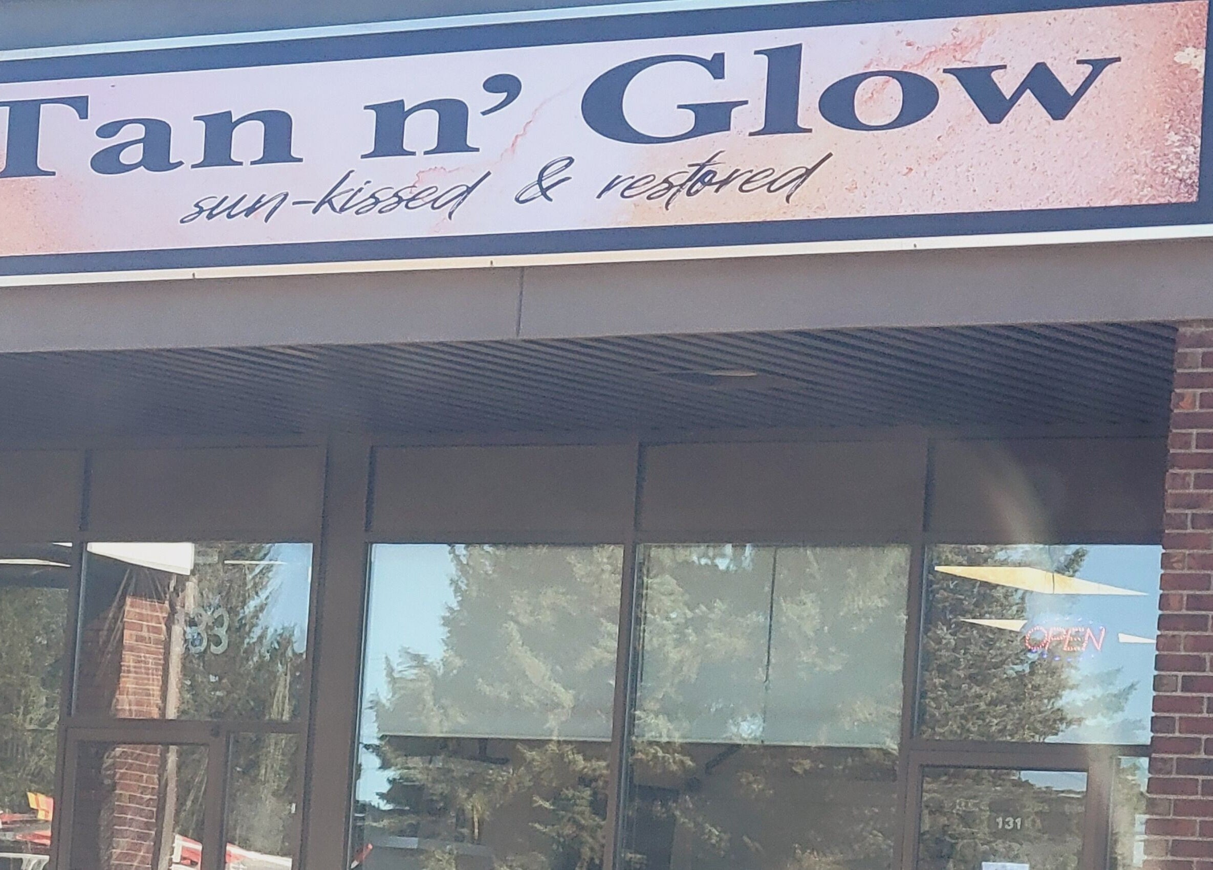 Entrance of Tan n'Glow in Medicine Hat, Alberta, CA showcasing stylish signage.