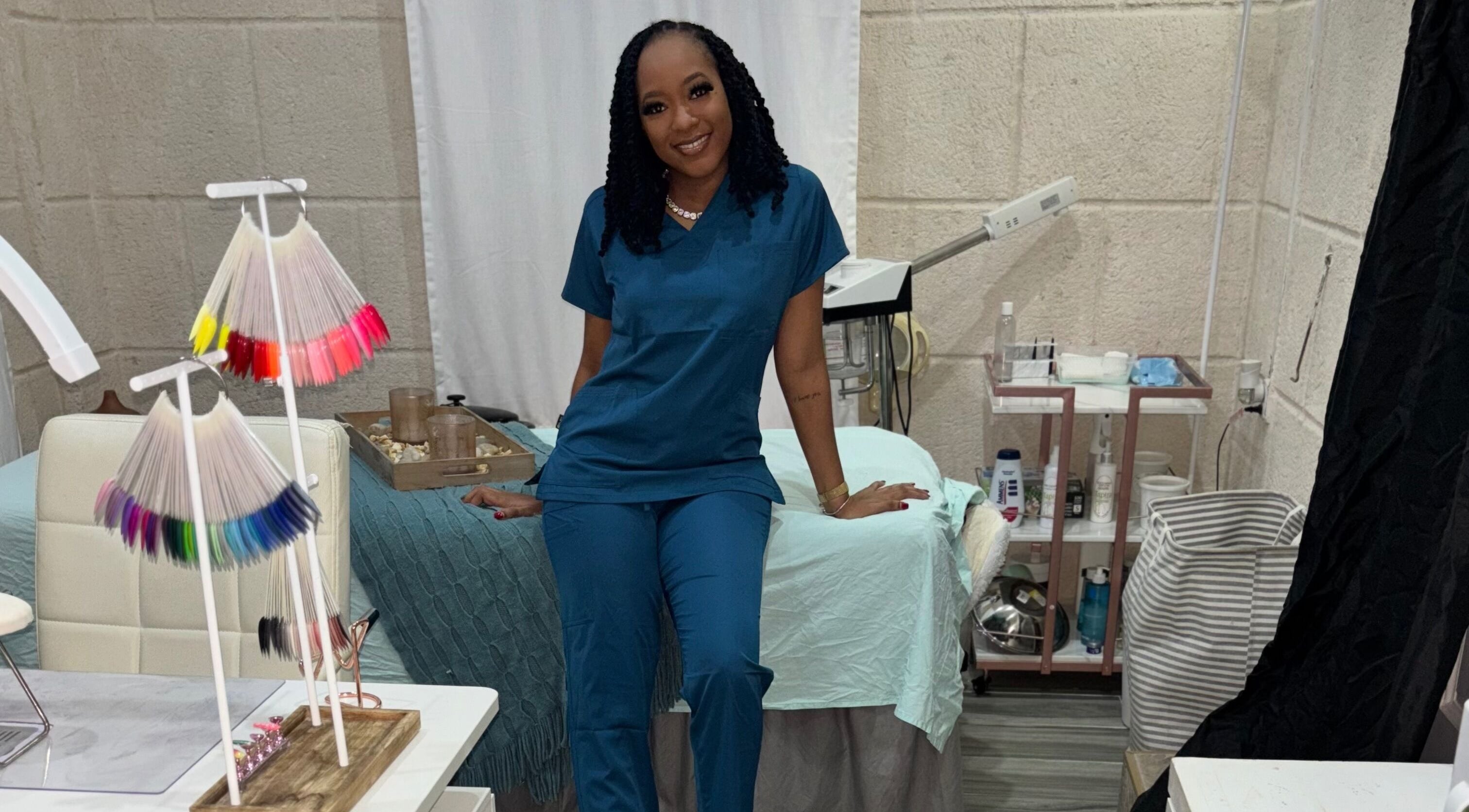 A professional at Aesthetiqs salon in Oistins, Christ Church, BB, showcasing nail color samples.