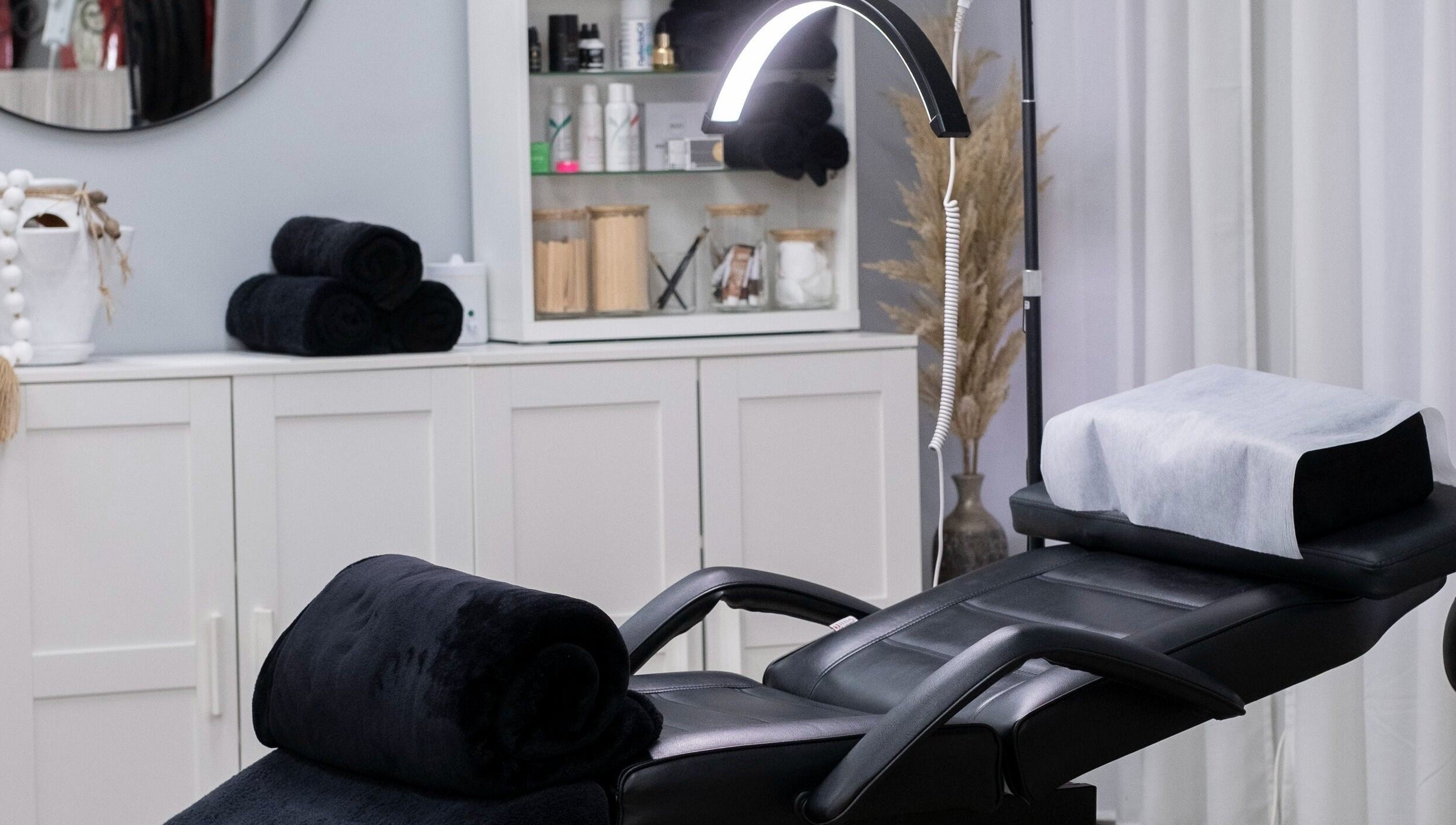 Spa treatment room at Lauren Elyse & Co, Woolooware, New South Wales, AU with a plush black recliner and elegant decor.