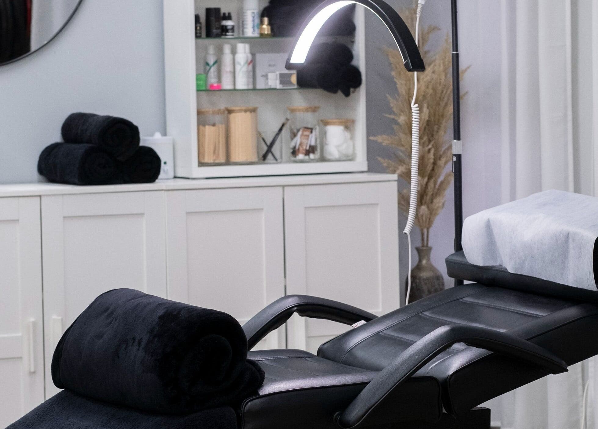 Spa treatment room at Lauren Elyse & Co, Woolooware, New South Wales, AU with a plush black recliner and elegant decor.