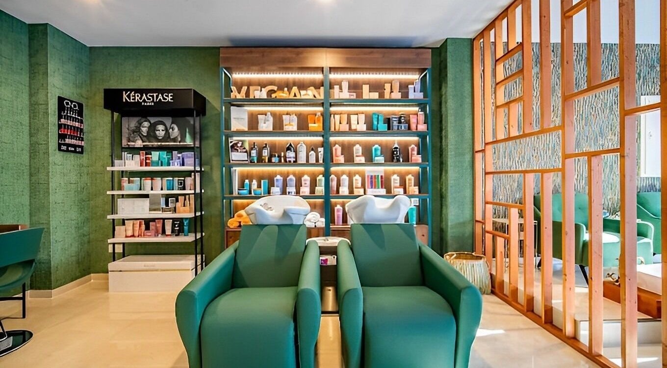 Interior de Mahra Experience en Marbella, Andalucía, ES con cómodas sillas y productos Kerastase en estantes.