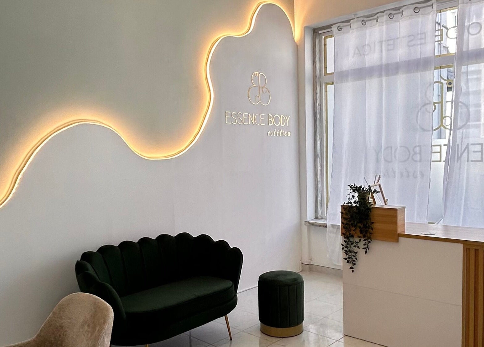 Receção moderna da Essence Body em Algueirão-mem Martins, Lisboa, PT. Sofá verde e iluminação suave.
